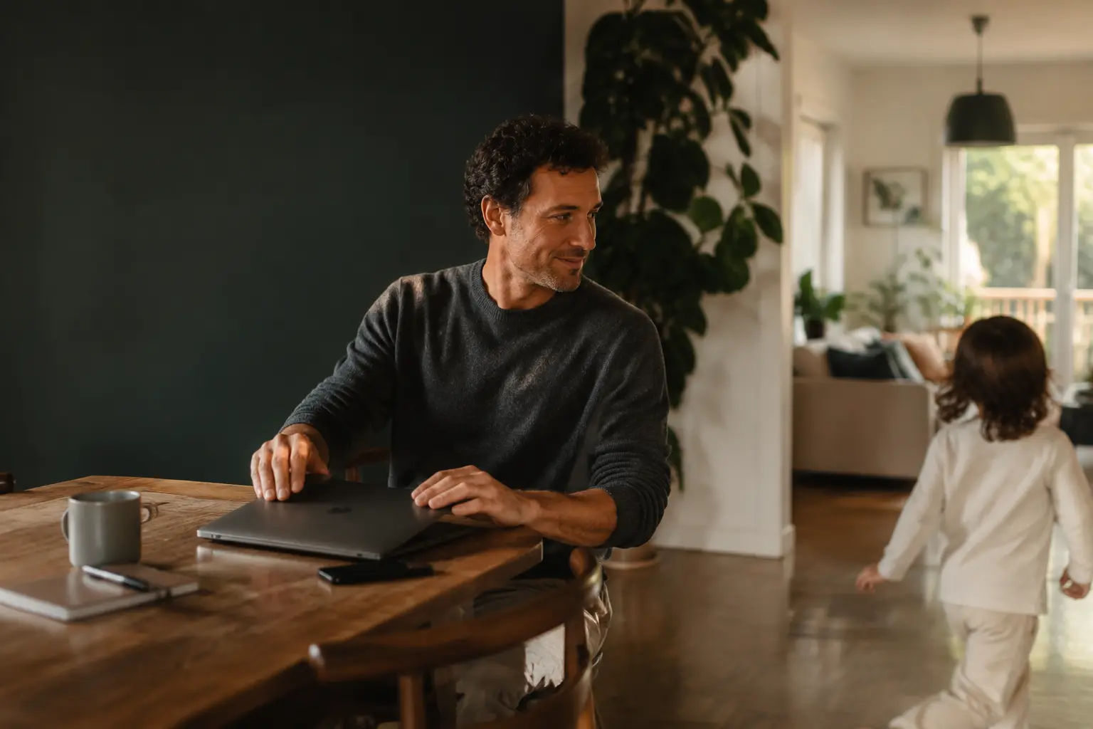 A professional closing a laptop and returning attention to family life